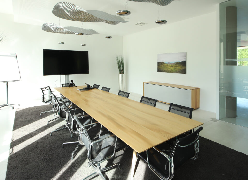 leerer Meetingraum mit großem Tisch und Flatscreen